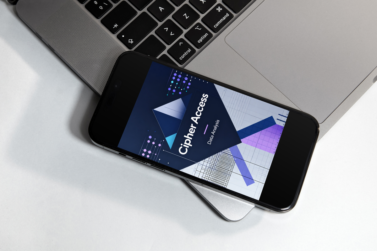 A black smartphone lying on a silver laptop, displaying the 'CipherAccess' dashboard on its screen against a clean white background.