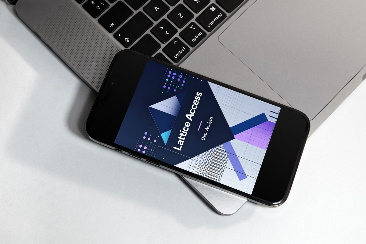 A black smartphone lying diagonally on a white surface, partially covering a silver laptop. The phone screen displays a dark-themed digital interface with the text 'Lattice Access' and 'DataVerse'.